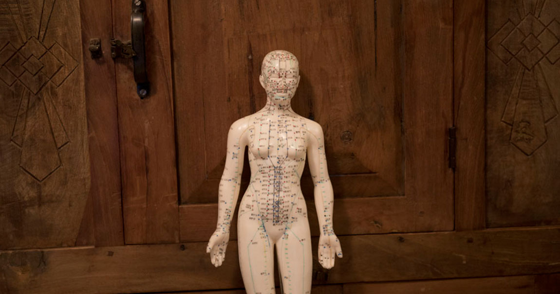 A map of acupuncture points printed onto a small female figurine.